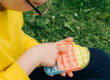 Anonymous child playing with colorful poppit sensory game. Close up of kid hands Push colorful trendy pop bubble flexible fidget toy.